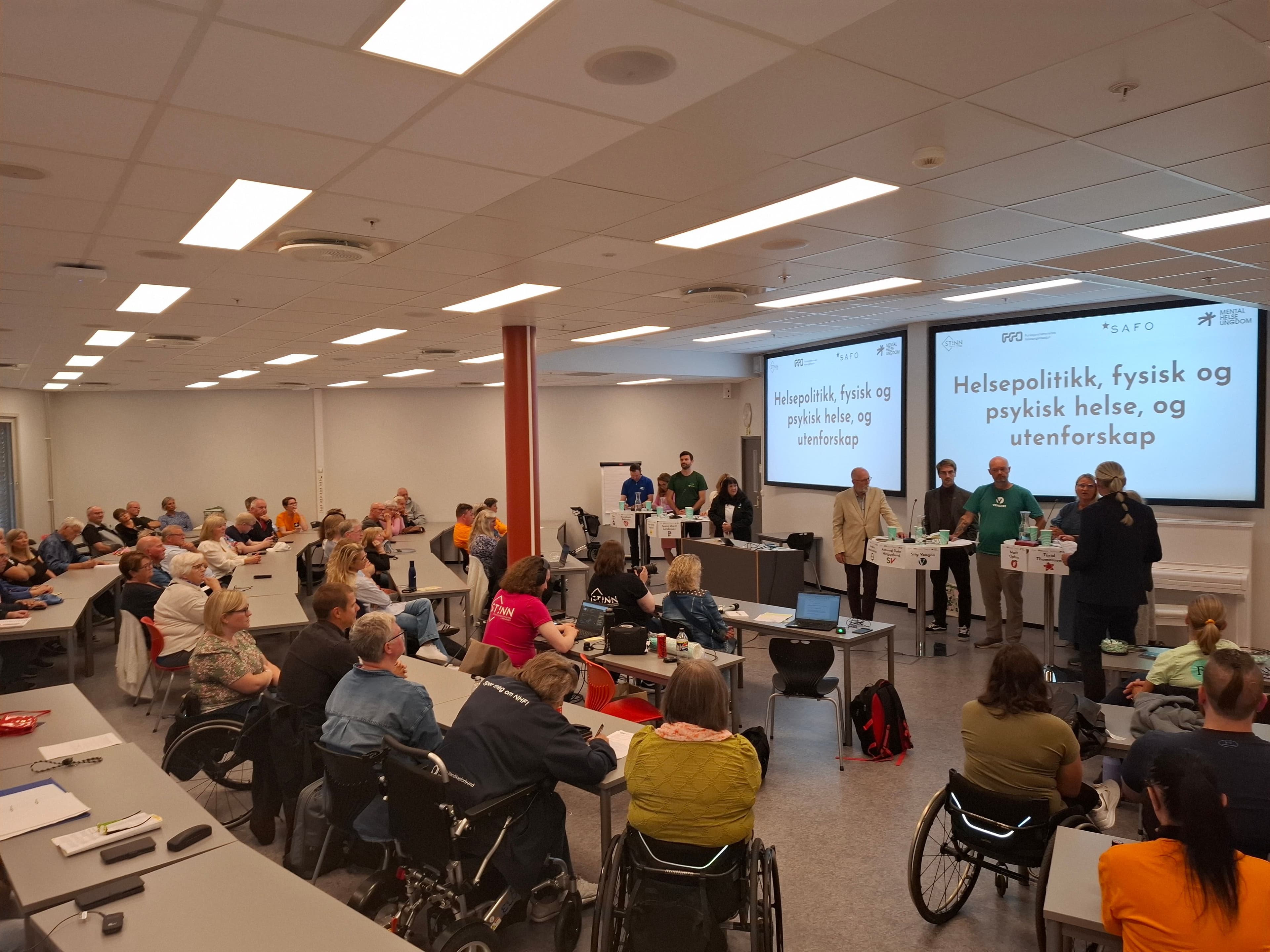 Bilde av forsamlingen og paneldebatten på Terningen Arena i Elverum 22. august 2025. Ca. 100 personer tok turen for å høre de politiske partiene debattere.